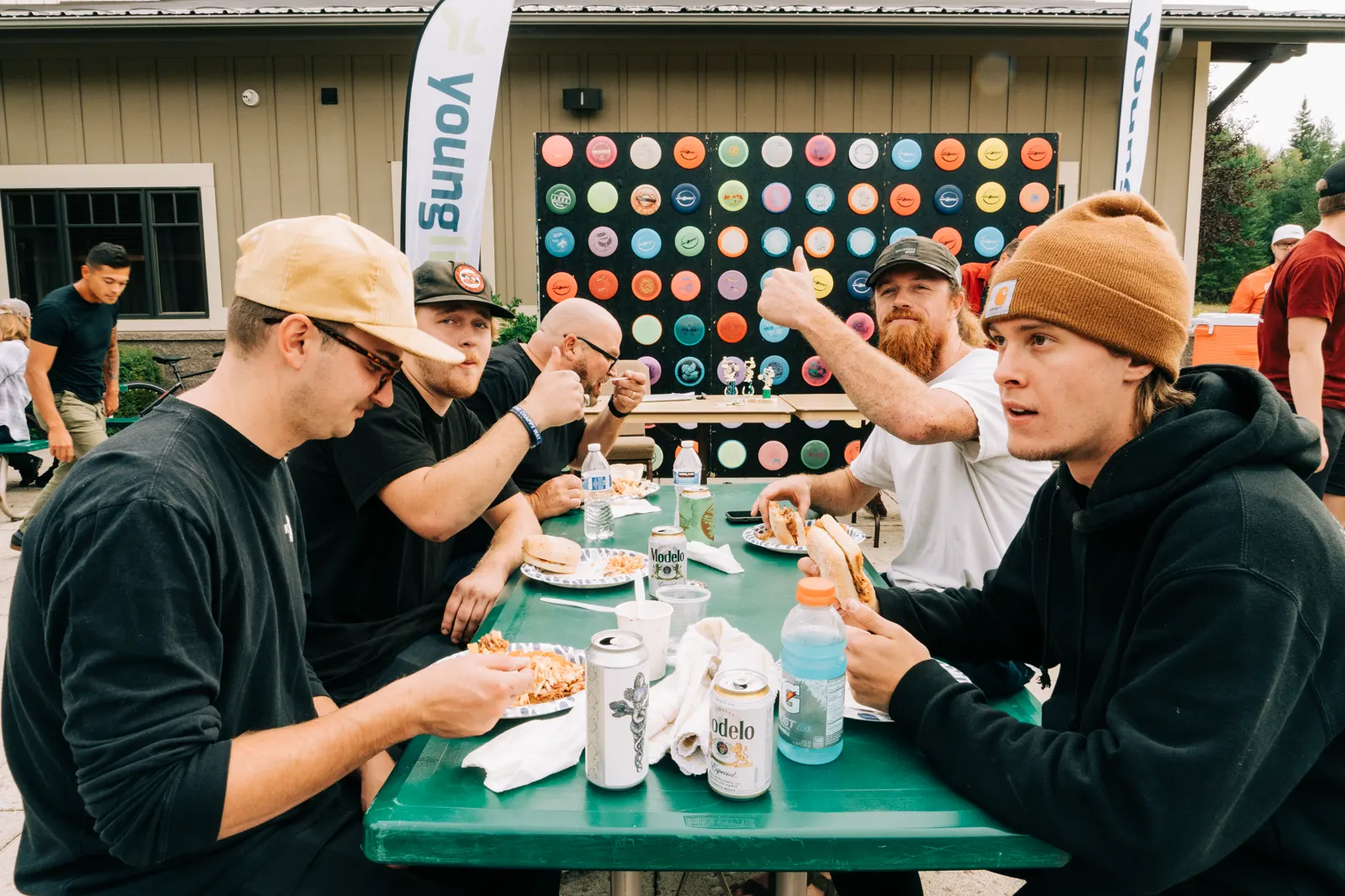 Players share lunch beside the Fish Toss disc wall.