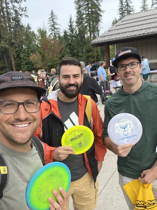 Three friends holding up their new discs
