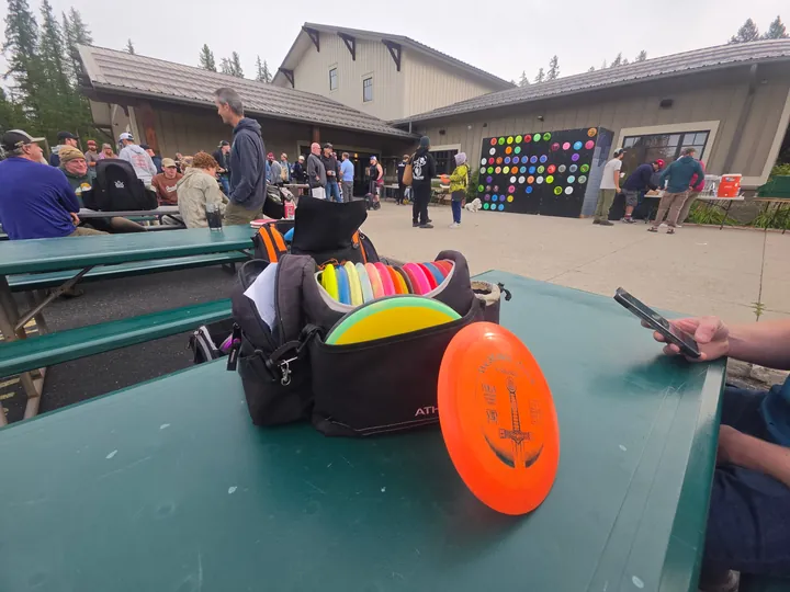A bag and a disc on a picnic table