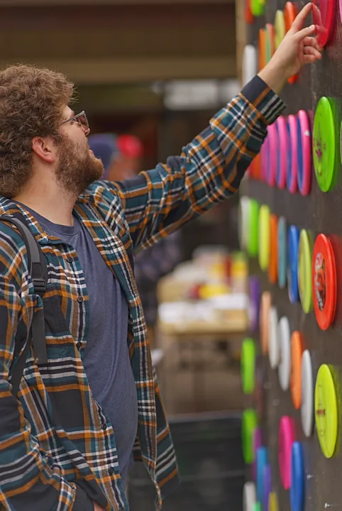 A player reaching for a disc on the wall