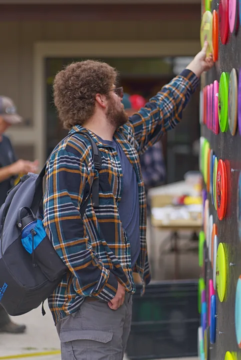 A player reaching for a disc on the wall
