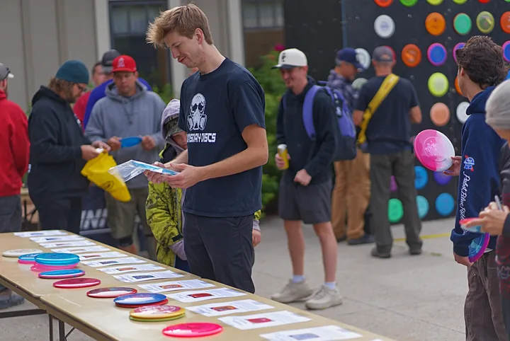 Players looking over the discs on the table