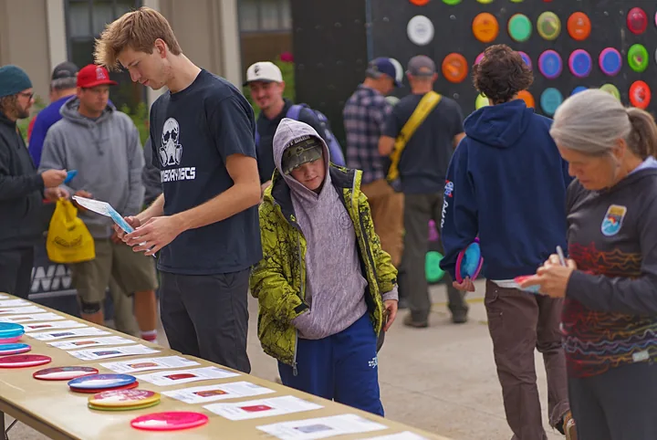 Players looking over the discs on the table