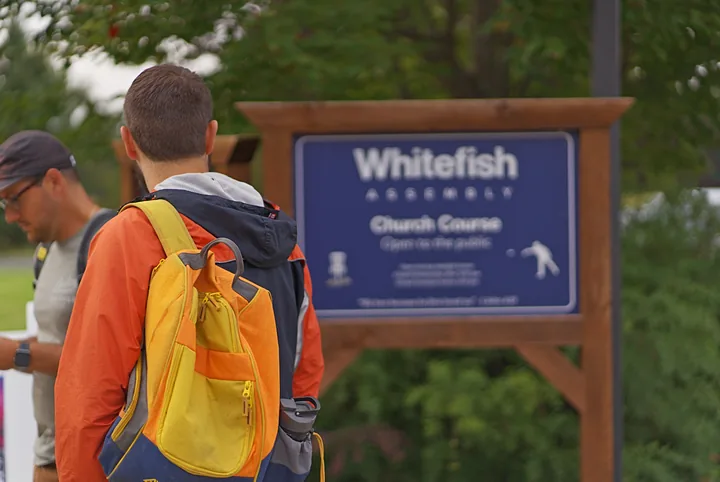 A player walking past the Church Course sign