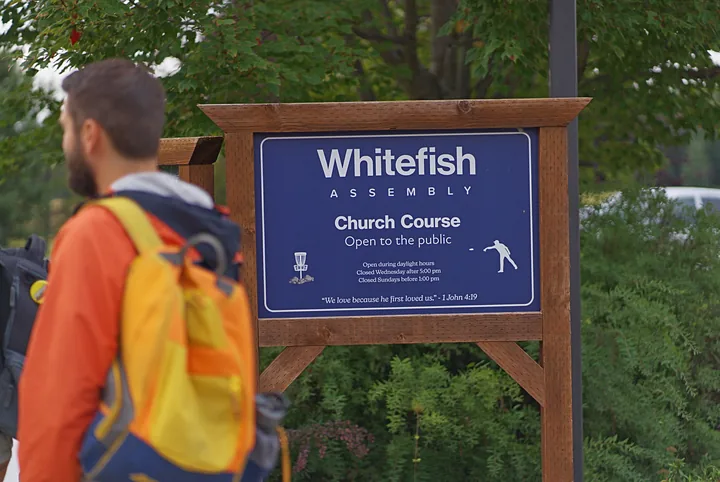 A player walking past the Church Course sign